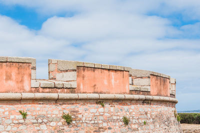 Low angle view of old building against cloudy sky