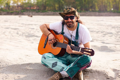 Man playing guitar on beach