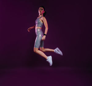 Full length of woman standing against black background