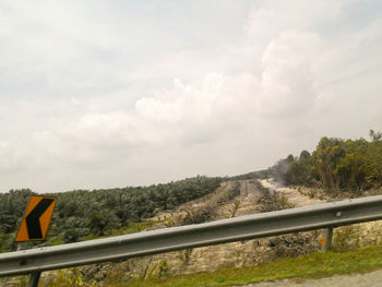 Scenic view of trees against cloudy sky