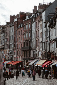 People walking on street against buildings in city