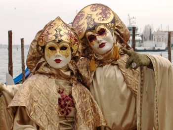 Two people wearing venetian masks