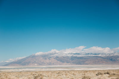 Scenic view of death valley desert against blue sky