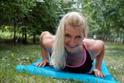 Portrait of young woman sitting on field