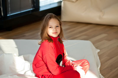 Portrait of smiling girl sitting at home