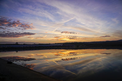 Scenic view of beach against sky at sunset