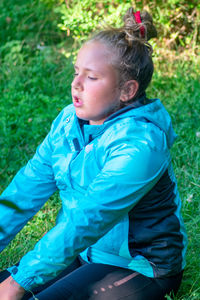 Girl looking away while sitting on land