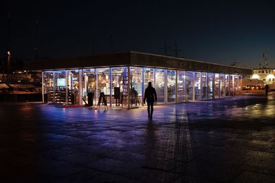 People walking on illuminated city at night