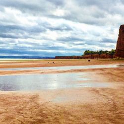 View of beach against cloudy sky