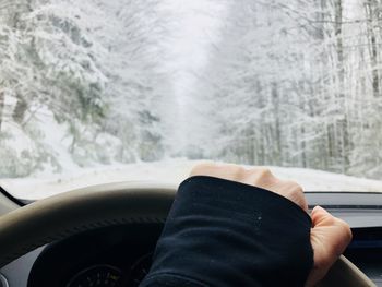 Cropped hand of person driving car