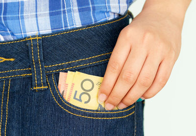 Close-up of hand removing paper currencies from pocket