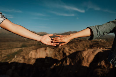 Midsection of woman hand on rock