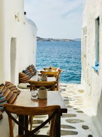 Chairs and tables outside restaurant by sea