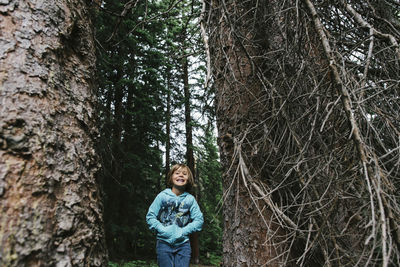 Cheerful girl standing in forest