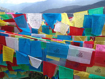 Close-up of multi colored flags hanging against sky