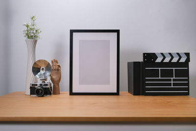 Close-up of electric lamp on table against wall at home