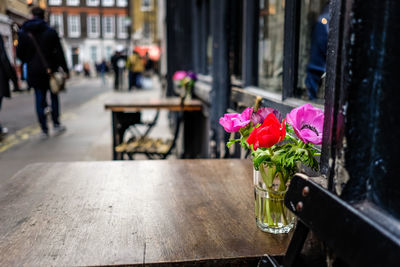 Close-up of pink flower vase on table at cafe