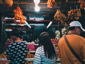 Rear view of people standing in market