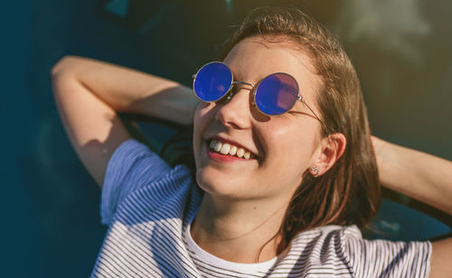 Young woman lying on car