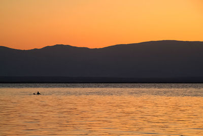 Scenic view of sea against orange sky