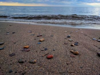 Close-up of pebbles on beach against sky