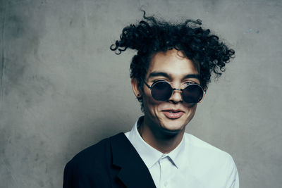 Portrait of young man standing against wall