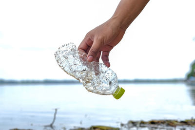 Close-up of hand holding glass bottle