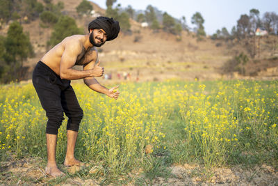 Young indian farmer working in the fields, growing crops. farming and agriculture concept.