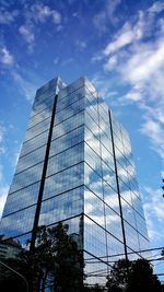 Low angle view of modern building against cloudy sky