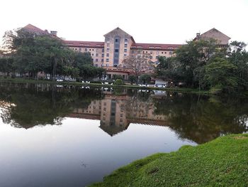 Reflection of buildings in lake against clear sky