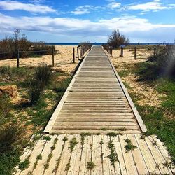 View of empty wooden bridge over river