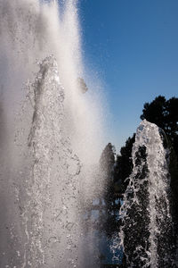 Waves splashing on water against sky