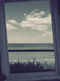 Scenic view of sea against sky seen through window