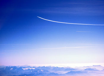 Scenic view of vapor trail against blue sky