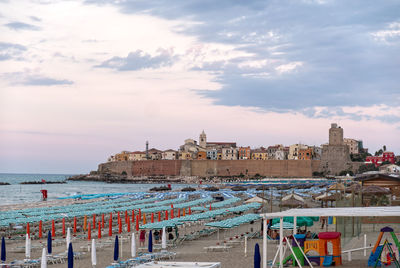 Panoramic view of the old town of termoli with beach umbrellas and svevo castle, termoli, italy