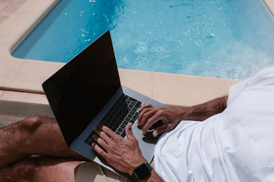 High angle view of man using mobile phone at swimming pool