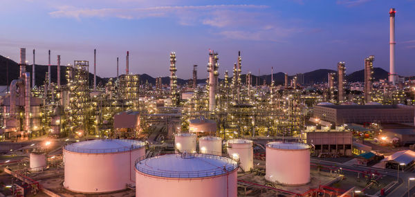 Aerial view oil and gas tank with oil refinery background at night, glitter lighting petrochemical.
