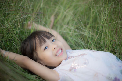 Portrait of smiling woman lying on land