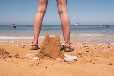 Low section of person standing on beach