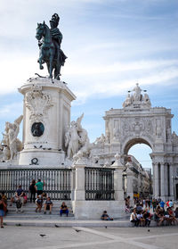 Statue in town square against cloudy sky