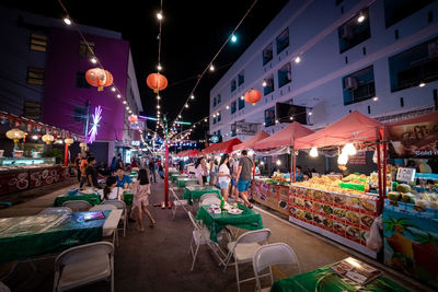 Illuminated street market in city at night