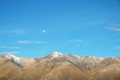 Scenic view of mountains against blue sky