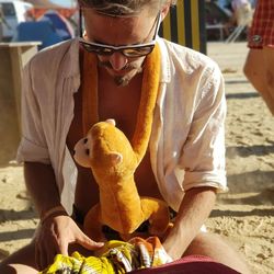 Midsection of man holding toy while sitting outdoors