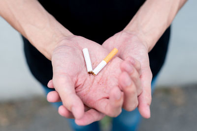Close-up of hand holding cigarette