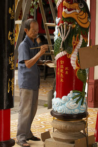 Portrait of a man painting the temple decoration