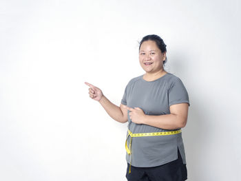 Portrait of smiling young woman against white background