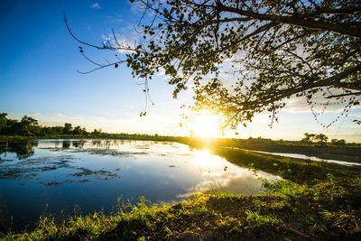 Scenic view of lake against sky at sunset