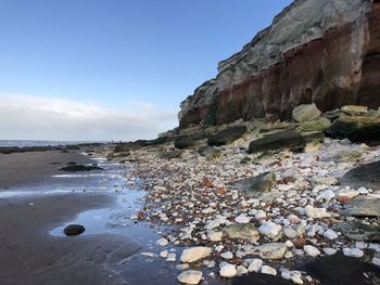 Rocks on beach against sky