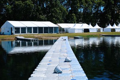 Built structure by lake against trees and plants