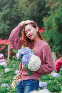 Portrait of beautiful young woman holding flower